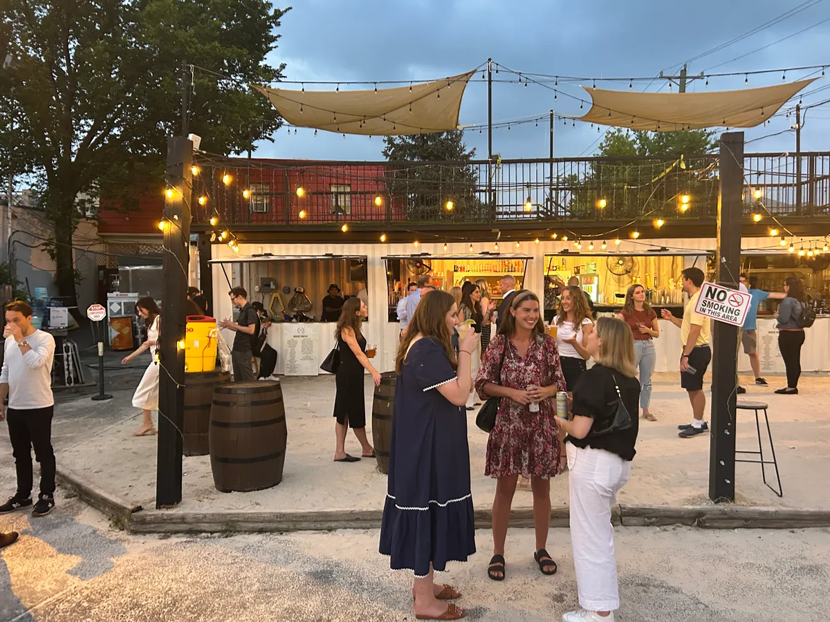 four women holding drinks while laughing together during daytime